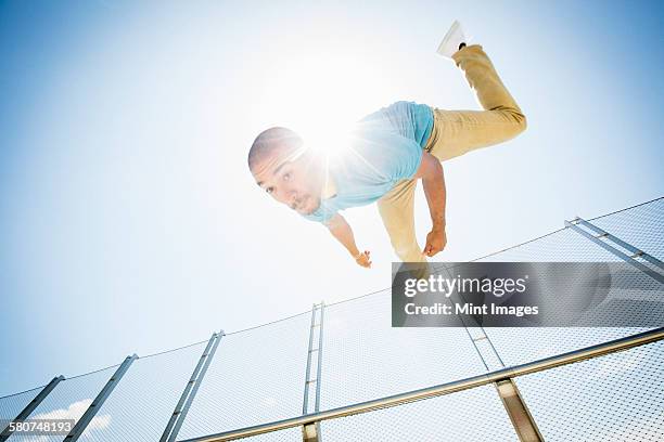 young man somersaulting on a bridge. - back flip bridge stock pictures, royalty-free photos & images