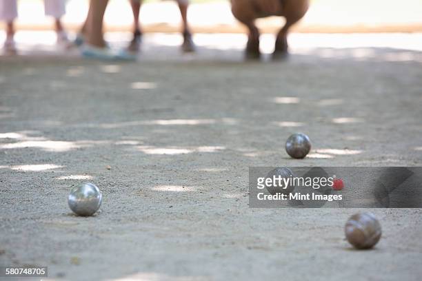 a boules game in progress on the sandy ground in the shade. - boules stock-fotos und bilder