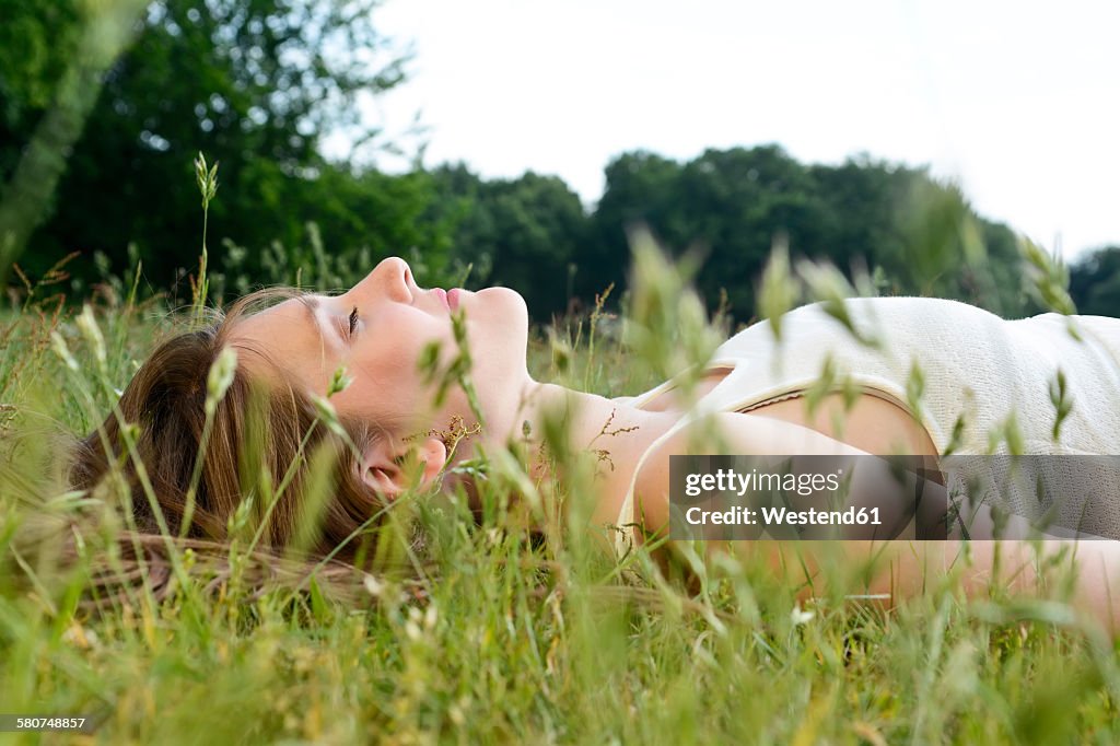 Young woman with closed eyes lying on a meadow