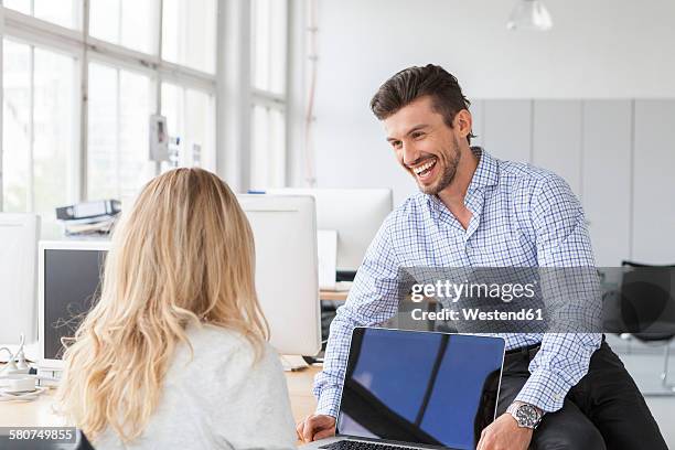 businessman communicating with colleague in an office - 辦公室戀情 個照片及圖片檔