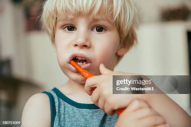 portrait of little boy brushing his teeth with an electric toothbrush - electric toothbrush stockfoto's en -beelden