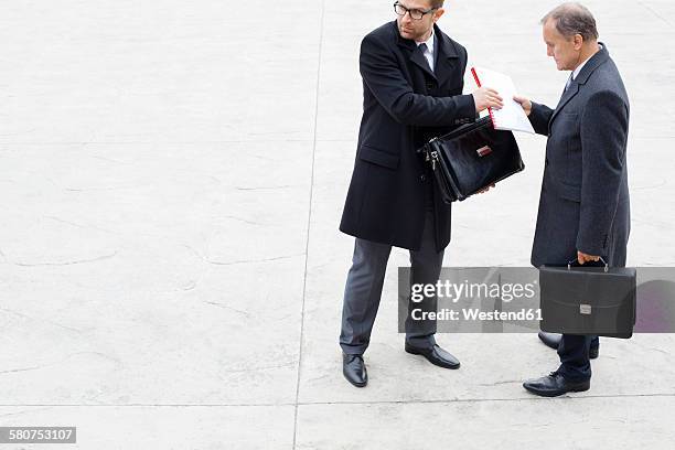 businessman handing over documents to partner secretly - whistle blower stock pictures, royalty-free photos & images