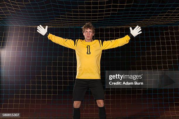 portrait of confident goalie defending soccer net on field - goalie fotografías e imágenes de stock