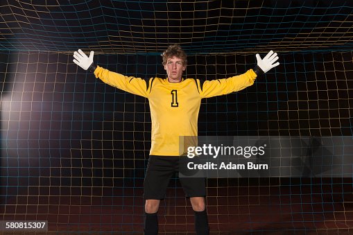 Portrait of confident goalie defending soccer net on field Portrait of confident goalie defending soccer net on field