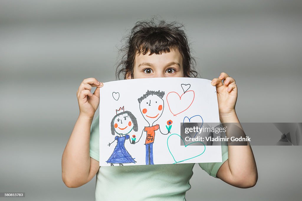 Portrait of girl showing painting over gray background