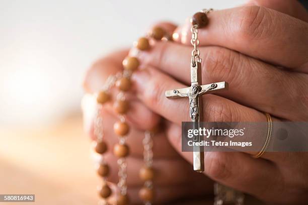 usa, new jersey, woman praying with rosary beads in hands - iglesia católica romana fotografías e imágenes de stock