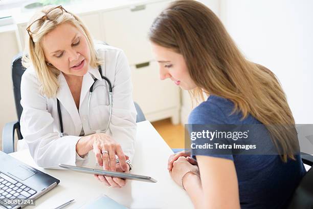 usa, new jersey, doctor talking to patient in office - woman talking doctor stock-fotos und bilder