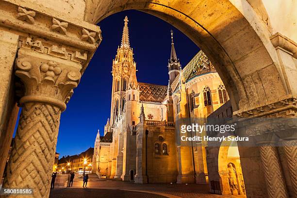 hungary, budapest, matthias church seen through arch of fishermans bastion - budapest stock pictures, royalty-free photos & images