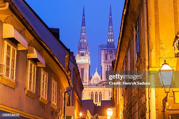 croatia, zagreb, illuminated street and spires of zagreb cathedral - zagreb stock pictures, royalty-free photos & images