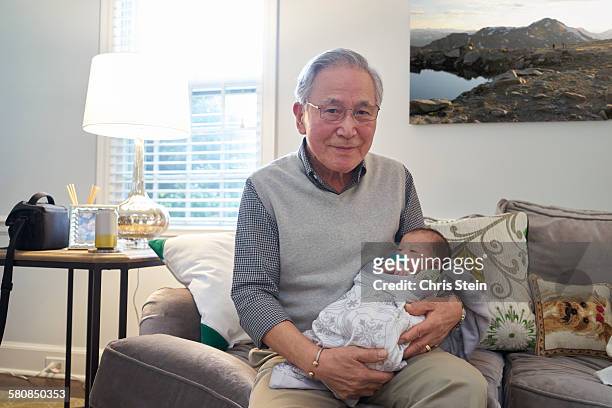 asian grandfather holding his asian grandson - old life new life stock pictures, royalty-free photos & images