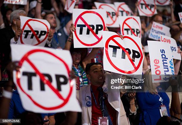 Delegates supporting Bernie Sanders wave TPP signs during opening proceedings at the Democratic National Convention in Philadelphia on Monday, July...