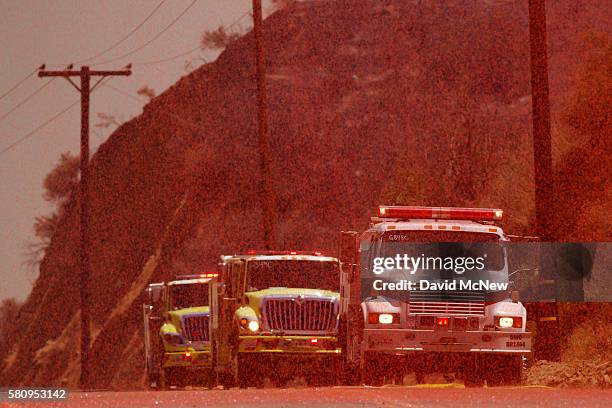 Fire retardant dropped by a helicopter rains down on firetrucks in Placerita Canyon at the Sand Fire on July 25, 2016 in Santa Clarita, California....