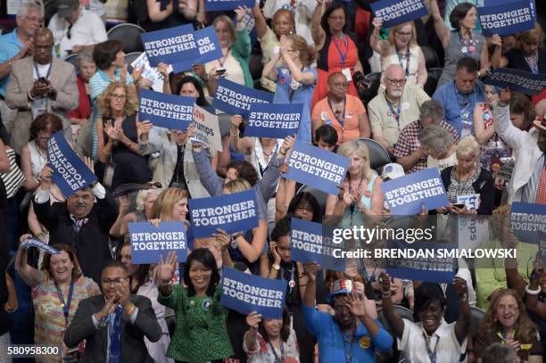 Delegates hois signs as International Disability Rights Advocate Anastasia Somoza addresses the audience on Day 1 of the Democratic National...