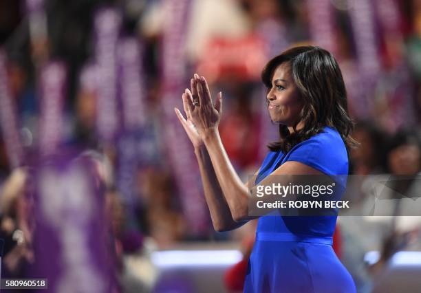 First Lady Michelle Obama applauds from the stage after addressing delegates on Day 1 of the Democratic National Convention at the Wells Fargo Center...