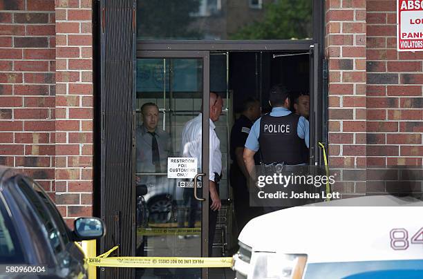 Chicago Police officers stand inside Lavanderia Soap Opera Laundromat as they investigate a shooting in the parking lot that killed professional...