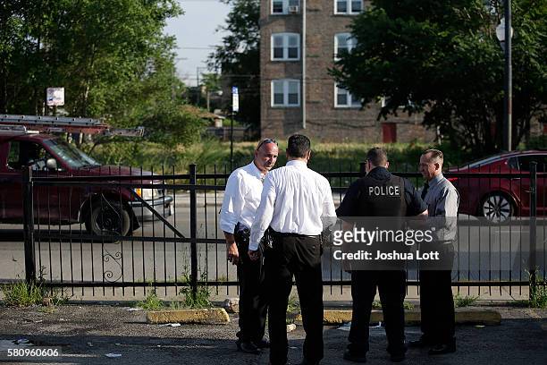 Chicago Police detectives and police officer stand outside the Lavanderia Soap Opera Laundromat and Keeler Food & Deli during an investigation of a...