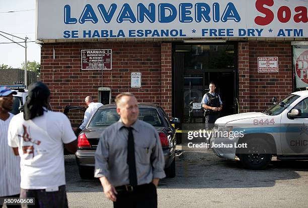 Chicago Police officers investigate a shooting that killed professional basketball player Jonathan Mills outside the Lavanderia Soap Opera Laundromat...