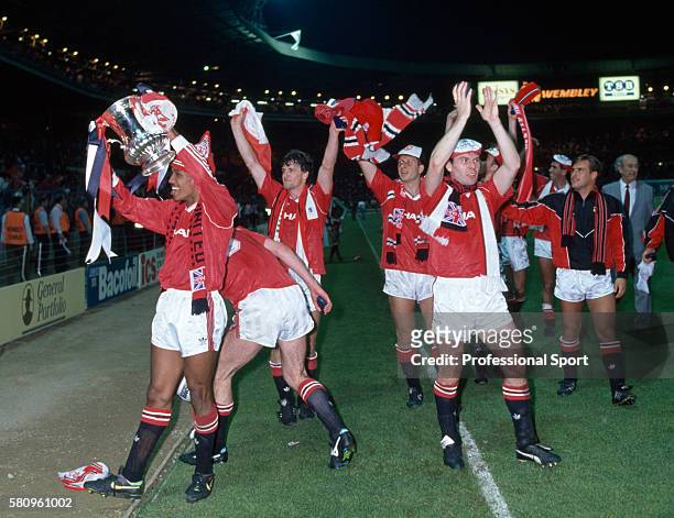 The Manchester United team celebrate after their victory in the FA Cup Final replay against Crystal Palace at Wembley Stadium on May 17, 1990 in...