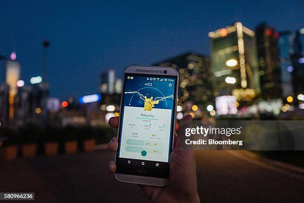 The Pikachu character of Nintendo Co.'s Pokemon Go augmented-reality game, developed by Niantic Inc., is seen on a smartphone in an arranged...