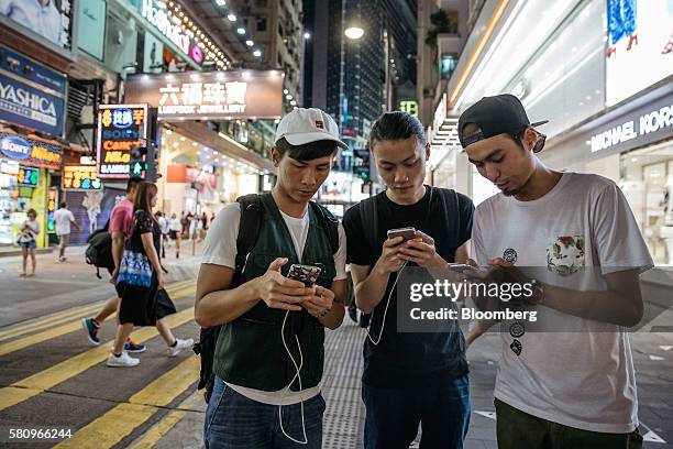 People play Nintendo Co.'s Pokemon Go augmented-reality game, developed by Niantic Inc., on their smartphones in the Causeway Bay area in Hong Kong,...