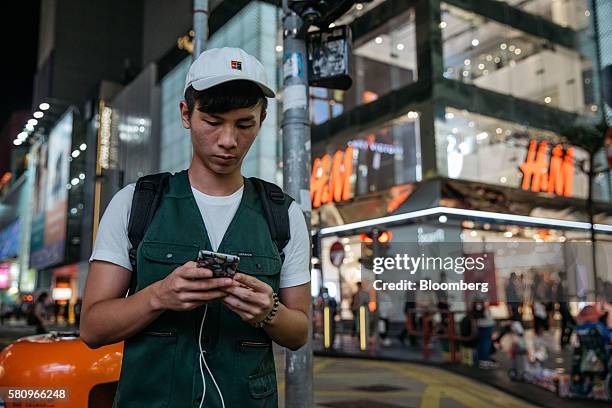 Gamer plays Nintendo Co.'s Pokemon Go augmented-reality game, developed by Niantic Inc., on his smartphone in the Causeway Bay district in Hong Kong,...