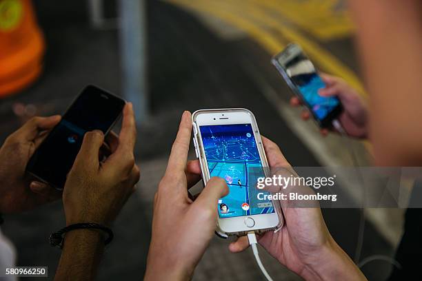 People play Nintendo Co.'s Pokemon Go augmented-reality game, developed by Niantic Inc., on their smartphones in Hong Kong, China, on Monday, July...