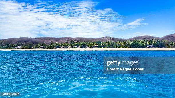 island village in fiji from a distance - fiji hut stock pictures, royalty-free photos & images