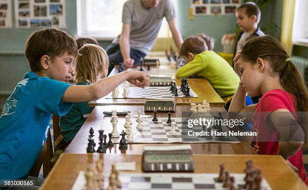 kids playing chess, indoors - ajedrez fotografías e imágenes de stock