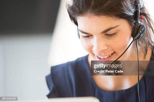 woman taking calls in call centre - call centre stock pictures, royalty-free photos & images