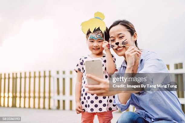 pretty mom & lovely little daughter taking selfie - funny mask stock pictures, royalty-free photos & images