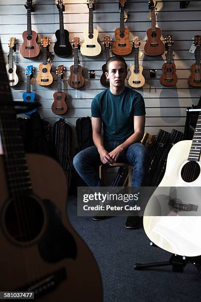 young man sat in music shop - collections stock-fotos und bilder