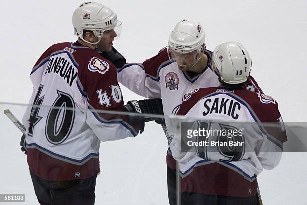 Alex Tanguay of the Colorado Avalanche is congratulated Milan Hejduk and Joe Sakic after Tanguay scored a goal in the first period against the New...