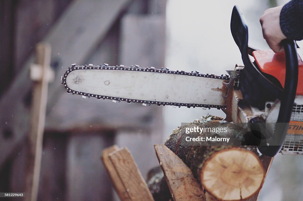 Cutting wood with a chainsaw on cold winter day