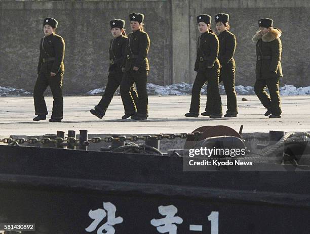 China - Female soldiers walk on the North Korean side of the Yalu River in this photo taken from Dandong on the Chinese side on Dec. 26, 2011