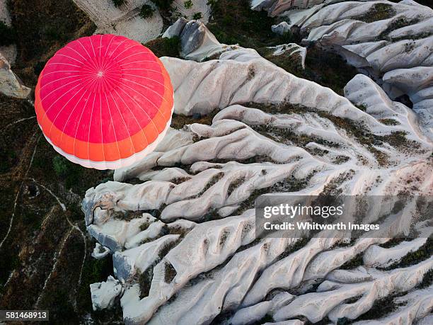 hot air ballon over eroded cappadocia ridges - göreme stock-fotos und bilder