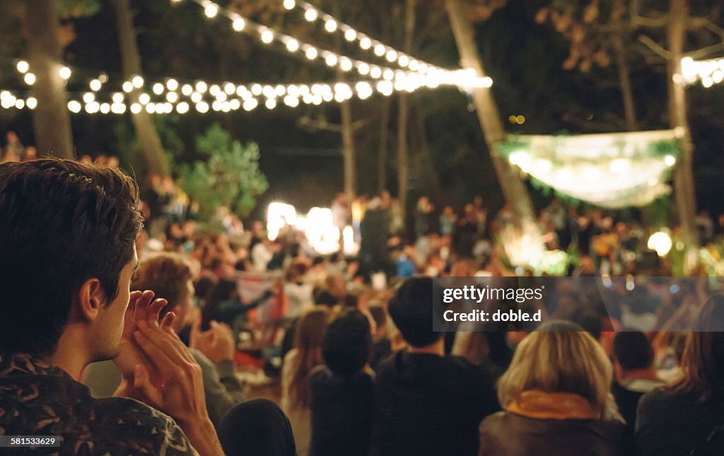 Young man clapping in night music festival