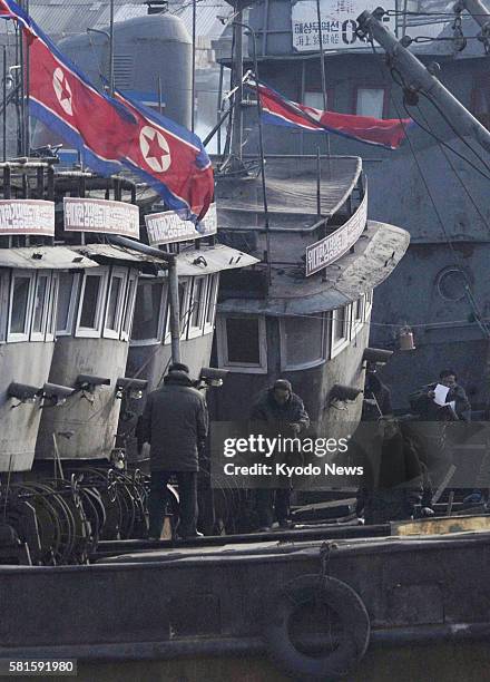 China - Photo taken from the Chinese border city of Dandong, Liaoning Province, shows people working on a ship in North Korea on Dec. 27, 2011.