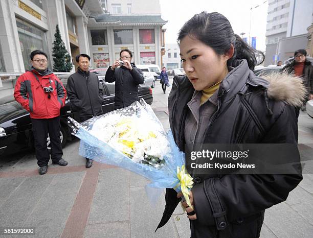 China - A North Korean woman heads to an event to mourn Kim Jong Il in Dandong, China, on Dec. 28 timed to coincide with the late leader's funeral in...