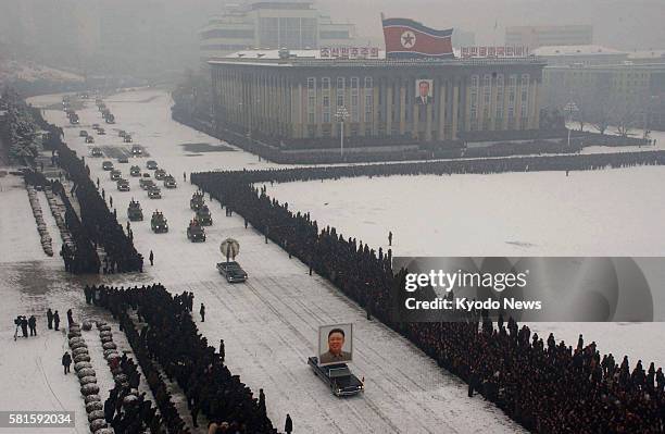 North Korea - The funeral motorcade including a car exhibiting a large portrait of the late Kim Jong Il drives by the Kim Il Sung Square in Pyongyang...