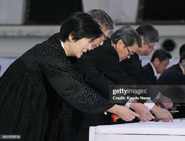 Japan - A woman cries as she and other mourners offer red carnations during a memorial service for North Korea's late leader Kim Jong Il, held by the...