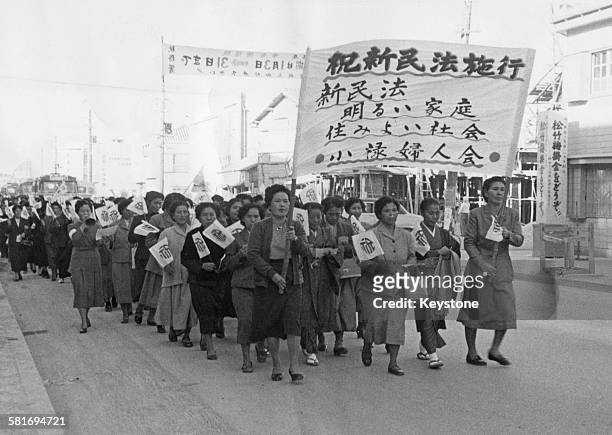 Women marching through downtown Naha in Okinawa Prefecture, Japan, in support of a new civil code giving equal rights to women, February 1957.