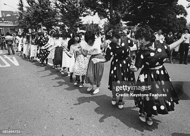 Takenoko-zoku dancers gather in Shibuya, Tokyo, Japan, dressed in distinctive colourful baggy clothing, 15th August 1980. Takenoko-zoku means 'bamboo...