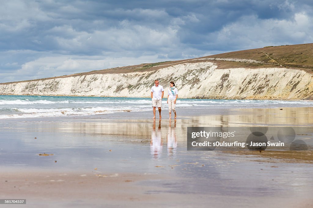 Married couple walking along the beach