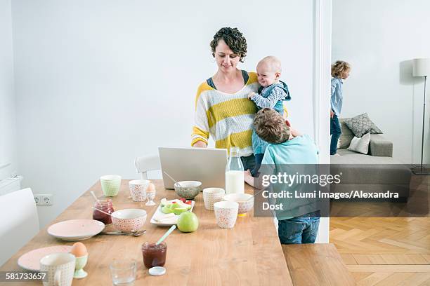 mother with laptop and children in kitchen - alexandra mora bildbanksfoton och bilder