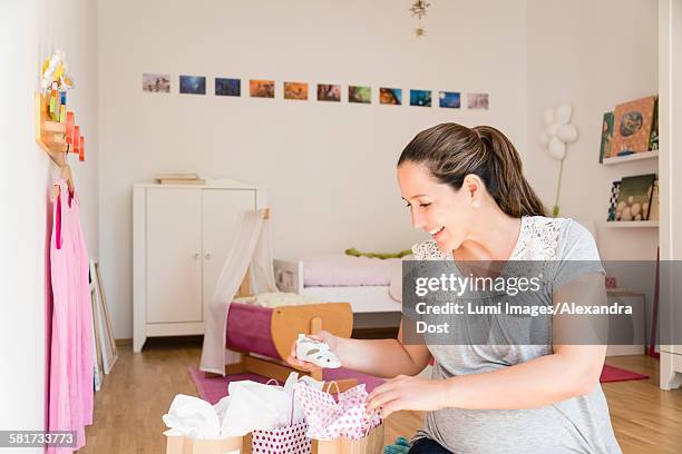 pregnant woman opening gifts at baby shower - alexandra dost stockfoto's en -beelden