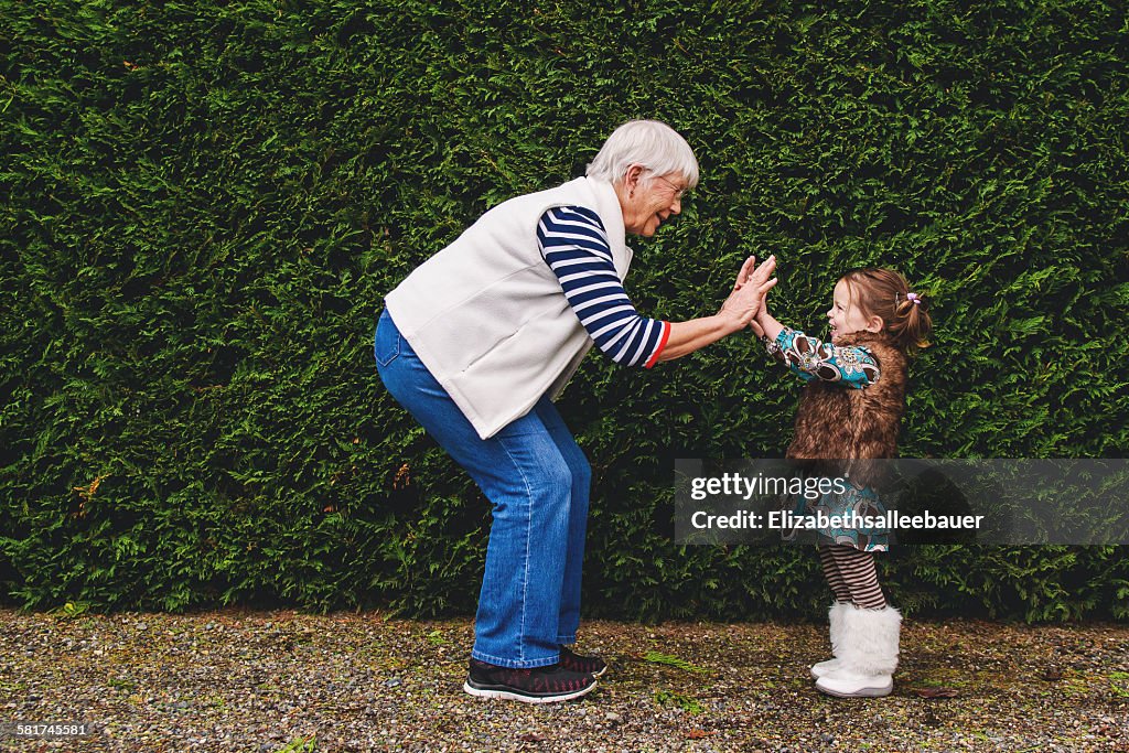 Girl playing pat-a-cake with her grandmother