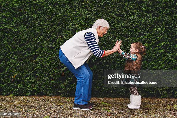 girl playing pat-a-cake with her grandmother - grandmother bildbanksfoton och bilder