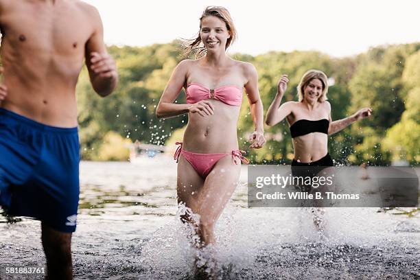group of friends running in lake - swimming trunks stock pictures, royalty-free photos & images