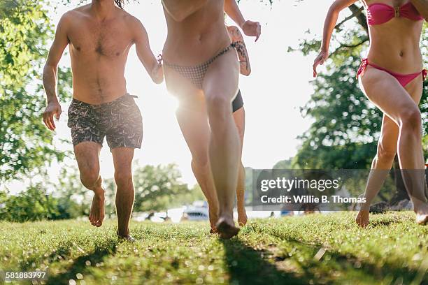 friends running at lake - zwembroek stockfoto's en -beelden