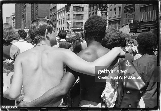 Back view of pair of shirtless men as they walk, arm in arm, during the first Stonewall anniversary march, then known as Gay Liberation Day , New...